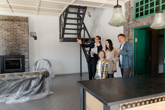 a%20small%20family%20and%20a%20person%20in%20a%20suit%20looking%20at%20a%20living%20room a%20small%20family%20and%20a%20person%20in%20a%20suit%20looking%20at%20a%20living%20room